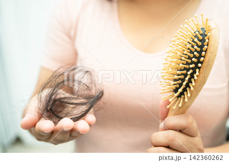 Asian woman have problem with long hair loss attach in her hand. Asian woman have problem with long hair loss attach in her hand. 142360262