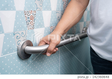Asian woman patient use toilet support rail in bathroom, handrail safety grab bar, security in nursing hospital. Asian woman patient use toilet support rail in bathroom, handrail safety grab bar, security in nursing hospital. 142360648