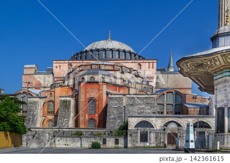 Hagia Sophia side view with domes and buttresses in Istanbul, Turkey. Byzantine architecture under sunny blue sky 142361615