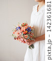 白いドレスの花嫁が持つ華やかなカラフルブーケ｜結婚式・ウェディングのフラワーシーン 142361681