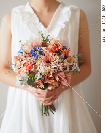 白いドレスの花嫁が持つ華やかなカラフルブーケ|結婚式・ウェディングのフラワーシーン 白いドレスの花嫁が持つ華やかなカラフルブーケ|結婚式・ウェディングのフラワーシーン 142361682