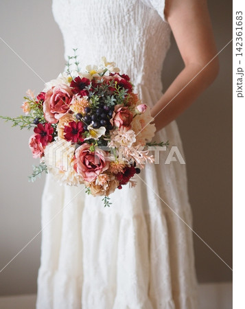 白いドレスの花嫁が持つ華やかなカラフルブーケ｜結婚式・ウェディングのフラワーシーン 142361683