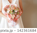 白いドレスの花嫁が持つ華やかなカラフルブーケ｜結婚式・ウェディングのフラワーシーン 142361684