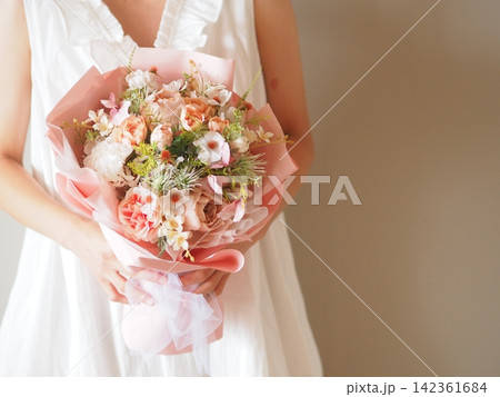 白いドレスの花嫁が持つ華やかなカラフルブーケ|結婚式・ウェディングのフラワーシーン 白いドレスの花嫁が持つ華やかなカラフルブーケ|結婚式・ウェディングのフラワーシーン 142361684