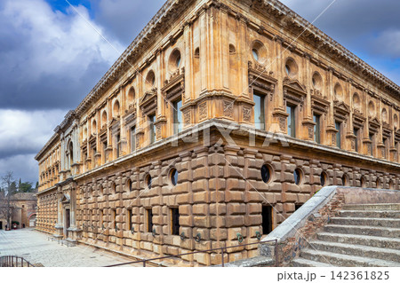 Renaissance Palace of Charles V facade in Alhambra fortress of Granada, Spain. Stone architecture under cloudy overcast sky 142361825