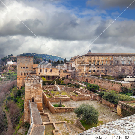 View from fortress walls towards Nasrid and Charles V palaces in Granada, Spain. Historic architecture under cloudy sky 142361826