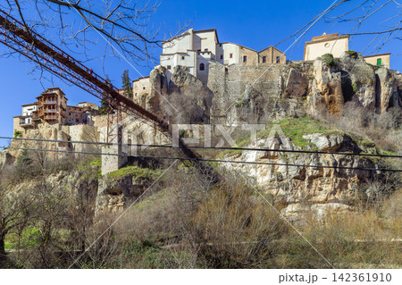 Hanging Houses and San Pablo Bridge over Huecar River canyon in Cuenca, Spain. Medieval stone architecture on rocks, no people. Hanging Houses and San Pablo Bridge over Huecar River canyon in Cuenca, Spain. Medieval stone architecture on rocks, no people. 142361910