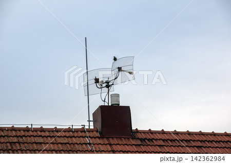 Rooftop Television Antenna Against Clear Blue Sky Rooftop Television Antenna Against Clear Blue Sky 142362984