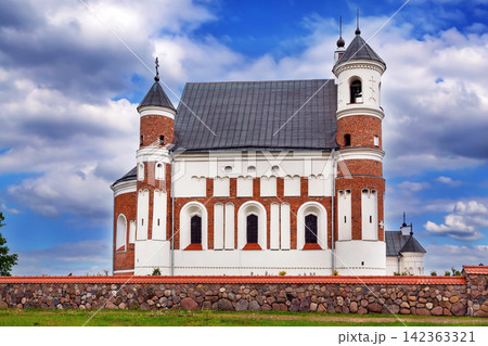 Fortified church side view in Murovanka, Belarus. Gothic and renaissance defense architecture under partly cloudy sky 142363321