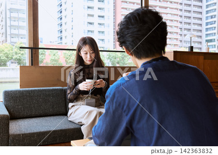 カフェでコーヒーを飲みながら会話する男女のカップル 142363832