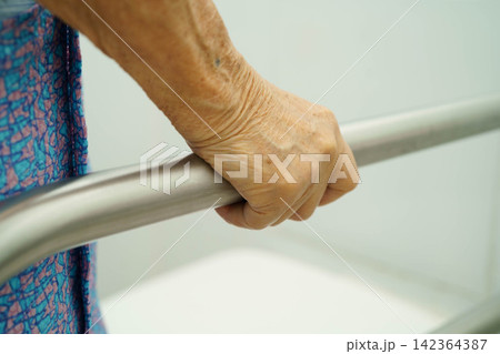 Asian elderly woman patient use toilet support rail in bathroom. Asian elderly woman patient use toilet support rail in bathroom. 142364387