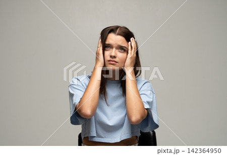Young woman experiencing stress and having a tension headache, feeling overwhelmed and anxious from problems Young woman experiencing stress and having a tension headache, feeling overwhelmed and anxious from problems 142364950