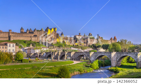 Panorama of Cite de Carcassonne in France, showing the fortress and historic bridge. Medieval architecture under blue sky 142366052