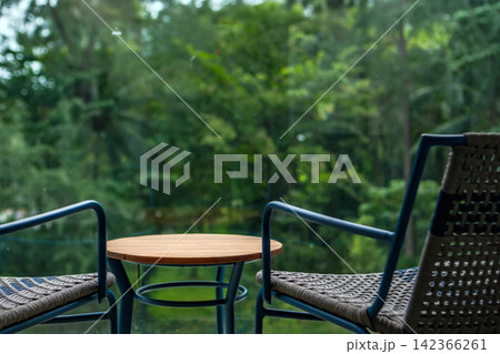 coffee table set at the balcony in hotel room with green trees forest outside in background 142366261