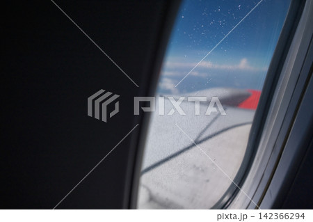 view from a window of air plane when flying on the cloud with air plane's wing outside view from a window of air plane when flying on the cloud with air plane's wing outside 142366294