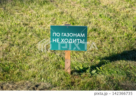 Green Restrictive Lawn Sign on Grass with Russian Text "Do Not Walk on Lawns" 142366735