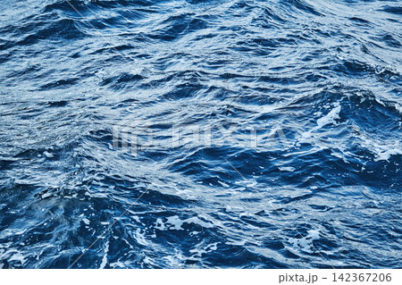 deep blue sea surface with wave by the heavy wind with many white bubble deep blue sea surface with wave by the heavy wind with many white bubble 142367206