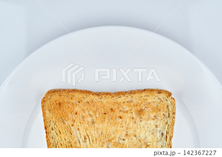 a part of golden crunchy toasted sliced whole wheat sandwich bread isolated on white dish and white background 142367227
