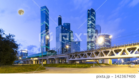 Moscow Central Circle (Little Ring, MCC, or MK MZD) and skyscrapers of the International Business Center (City) at night, with the super moon, Russia. Delovoy Tsentr railway station Moscow Central Circle (Little Ring, MCC, or MK MZD) and skyscrapers of the International Business Center (City) at night, with the super moon, Russia. Delovoy Tsentr railway station 142367400