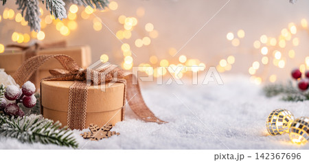 Rustic Gift Boxes on Snow with Frosted Pine and Warm Lights Rustic Gift Boxes on Snow with Frosted Pine and Warm Lights 142367696