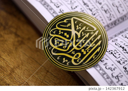 Sign with Al Quran inscription on Muslim holy book in mosque. Details of arabic calligraphy 142367912