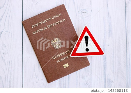 Austria passport with exclamation sign on wooden table. Problems with citizenship in Europe 142368118