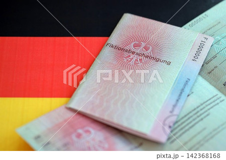 German temporary Permanent resident card lies on Germany flag. Fiktionsbescheinigung 142368168