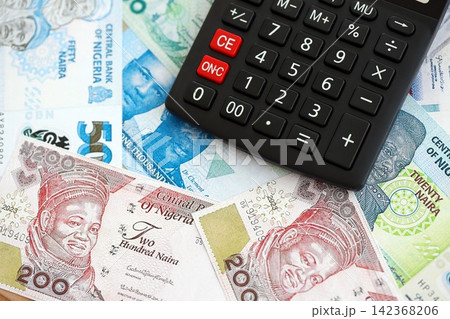 Nigerian naira currency money bills and calculator. The concept of taxation and money count Nigerian naira currency money bills and calculator. The concept of taxation and money count 142368206