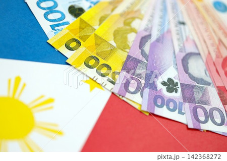Philippines peso currency money bills lies on flag. The concept of business and investment 142368272