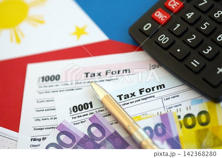 Philippines peso money bills and calculator with tax form on flag. Taxation and accounting concept 142368280