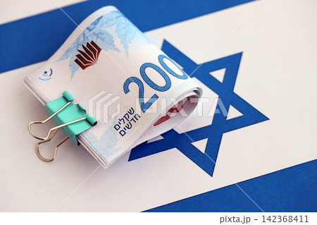 Israel New Shekels banknotes on national flag. The current Israel money bills lies on flag in big amount 142368411