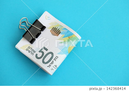 Israel New Shekels banknotes on blue background. The current Israel money bills lies on blue Israel New Shekels banknotes on blue background. The current Israel money bills lies on blue 142368414