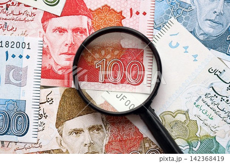 Pakistan rupees banknotes and magnifying glass. The current Pakistan money bills with loupe 142368419