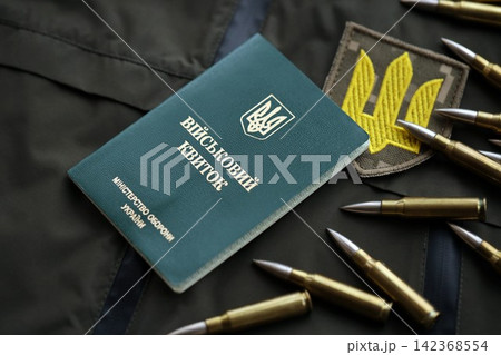 Military token or army ID ticket lies on green ukrainian military uniform Military token or army ID ticket lies on green ukrainian military uniform 142368554
