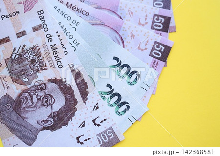 Mexican pesos money bills in big amount lies on yellow color table close up 142368581