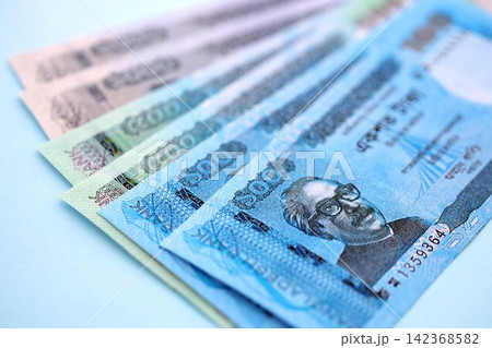 Bangladeshi taka money bills in big amount lies on teal color table close up Bangladeshi taka money bills in big amount lies on teal color table close up 142368582