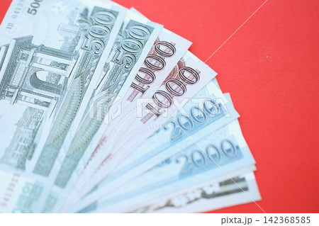 North Korean won money bills in big amount lies on red color table close up North Korean won money bills in big amount lies on red color table close up 142368585