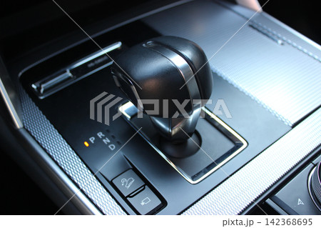 Car Center Console with dials, buttons and gear knob. Variety upholstery for controls and gear lever in modern vehicle Car Center Console with dials, buttons and gear knob. Variety upholstery for controls and gear lever in modern vehicle 142368695