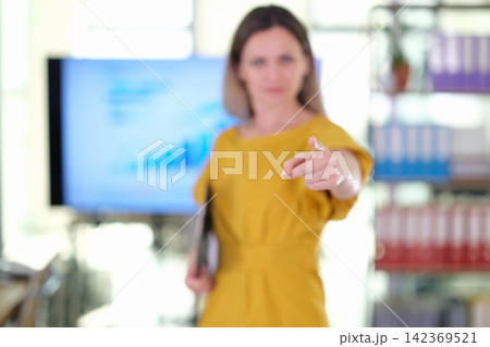 Businesswoman points forward during focused office presentation 142369521