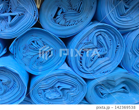 Bright blue rolls of material stacked in a neat, organized display 142369538