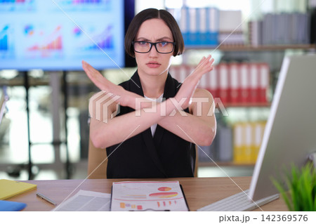 Worried female leader shows NO gesture in corporate environment Worried female leader shows NO gesture in corporate environment 142369576