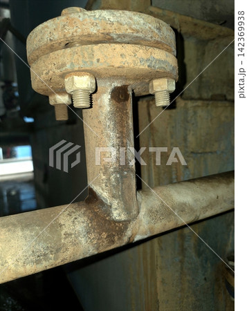 Rusty Industrial Pipe Flange Showcasing Age and Wear in a Factory Setting 142369938