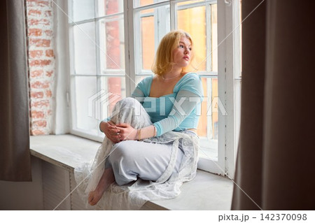 Contemplative woman with textured brick background and gentle lighting Contemplative woman with textured brick background and gentle lighting 142370098