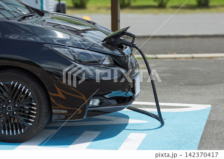 充電ステーションで充電中の電気自動車 充電ステーションで充電中の電気自動車 142370417