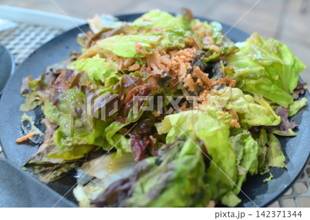レタスと葉野菜をたっぷり盛り付けたヘルシーなサラダのクローズアップ 142371344