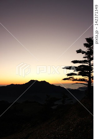 愛媛県・石鎚山系瓶ヶ森から見る 日没後のマジックアワーに染まる雲海と石鎚山の雄大なシルエット 愛媛県・石鎚山系瓶ヶ森から見る 日没後のマジックアワーに染まる雲海と石鎚山の雄大なシルエット 142371349