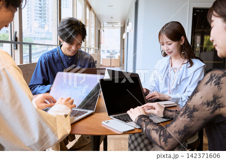 カフェでノートパソコンを使いミーティングをする若いビジネスパーソン カフェでノートパソコンを使いミーティングをする若いビジネスパーソン 142371606