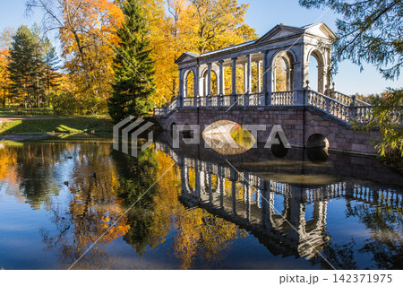 Historic Stone Bridge in Autumn Park with Lake Reflection Historic Stone Bridge in Autumn Park with Lake Reflection 142371975