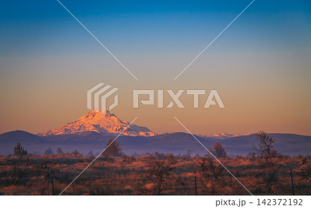 Snowy Mountain at Sunset with Wide Blue Sky and Rural Landscape Snowy Mountain at Sunset with Wide Blue Sky and Rural Landscape 142372192