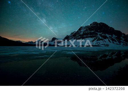 Milky Way Over Snowy Mountains and Reflective Alpine Lake 142372208